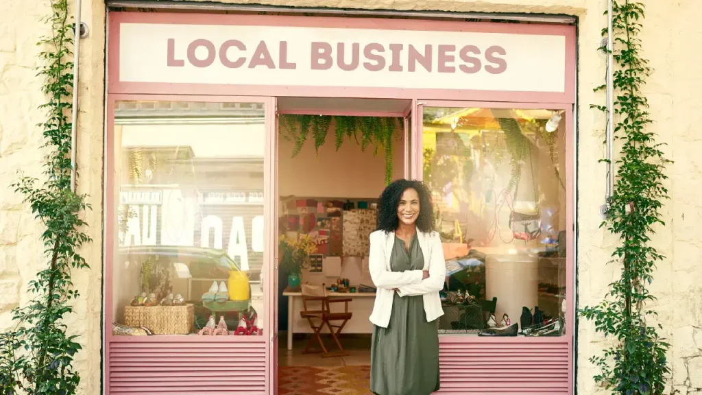 a woman standing outside the store which is a local business